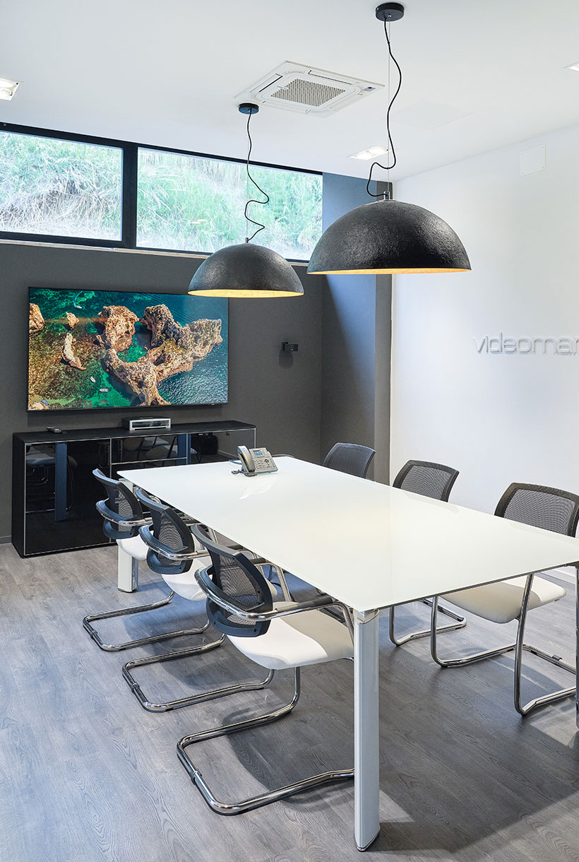Sala riunioni con grande tavolo e monitor