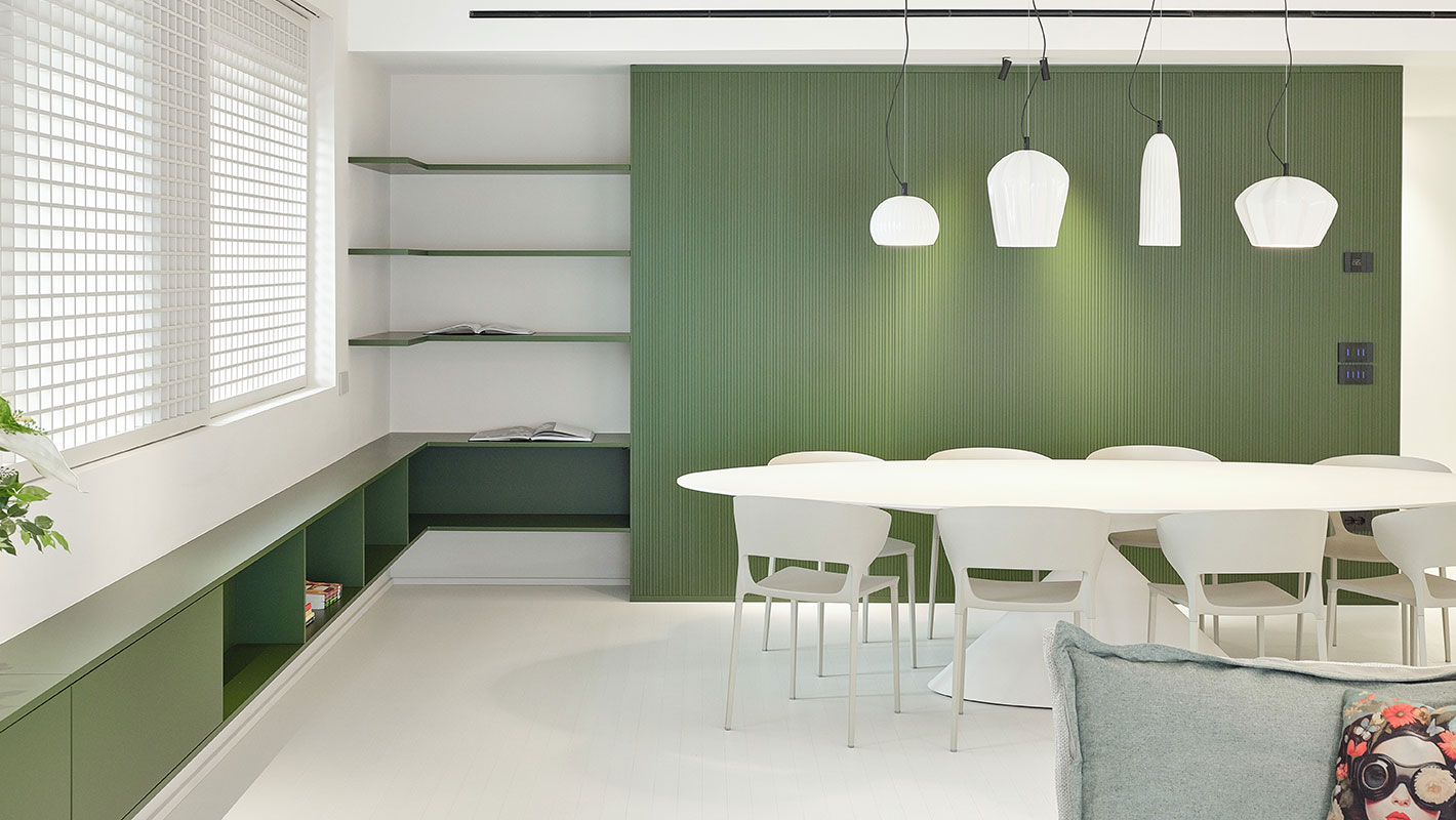 Living open space verde con grande tavolo