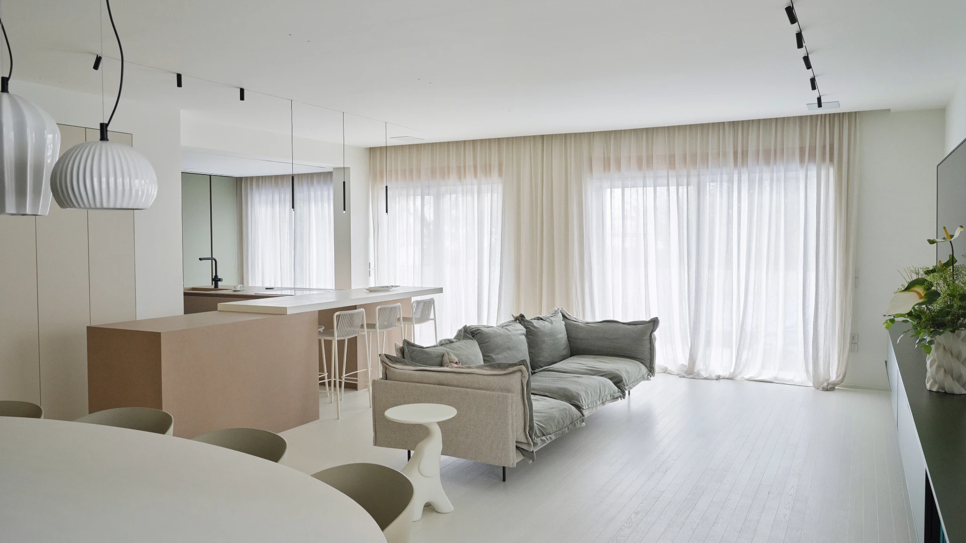 Living open space con divano lineare e cucina con isola ad angolo