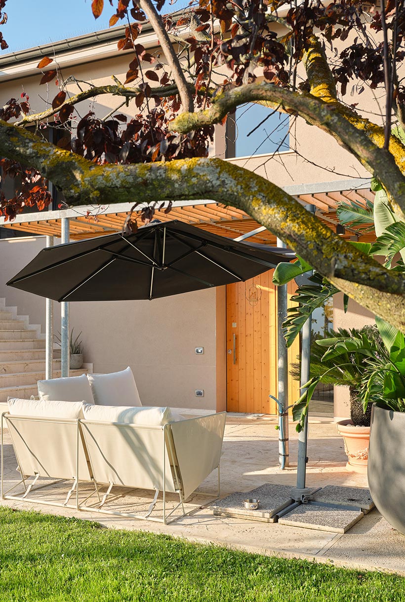 Facciata esterna della casa con un patio e divani da esterno