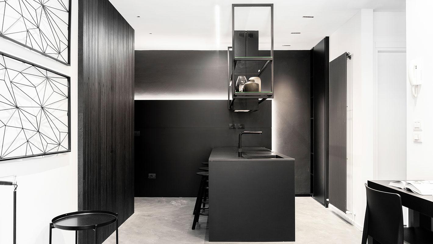 Cucina sui toni del nero e grigio in un miniappartamento