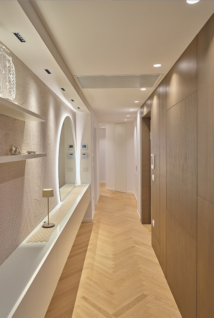 Ingresso allestito con boiserie in rovere e parete specchio