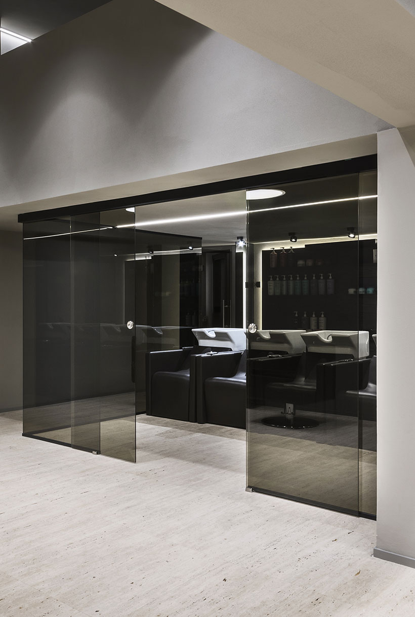 Hair spa di una parruccheria contemporanea divisa da parete in vetro fumè